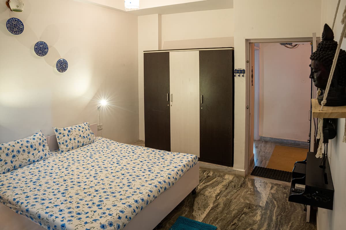 Ein Schlafzimmer mit Bett, Kleiderschrank und einer Statue.