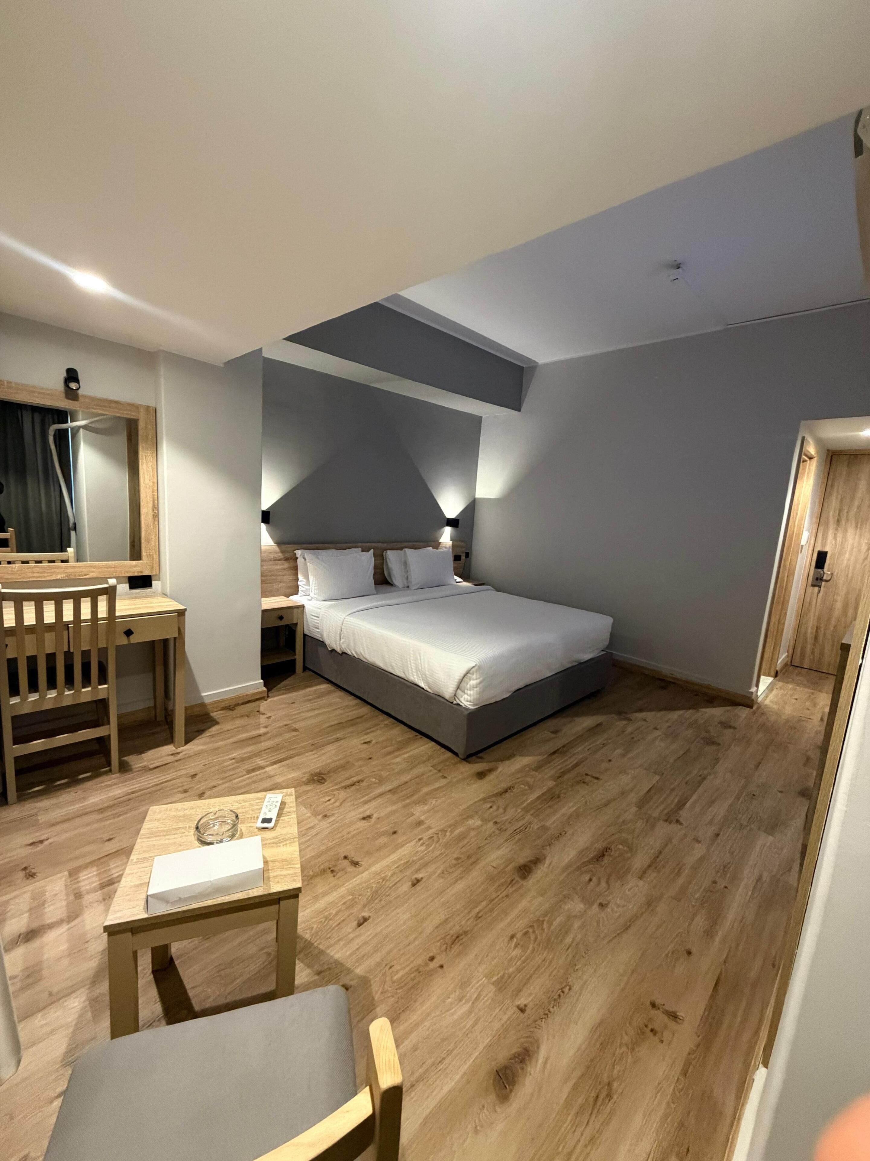 Ein modernes Schlafzimmer mit Bett, Nachttisch, Stuhl und Schreibtisch mit Spiegel.
