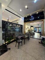 Un hall d’hôtel comprenant des espaces aménagés avec des sièges, un comptoir d’accueil et une enseigne indiquant « The Hybrid Lounge ».
