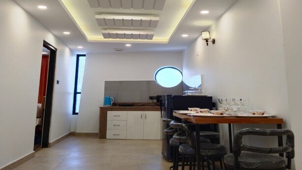 Cuina moderna amb zona de dinar, que destaca per una illa central, tamboretes de bar i il·luminació empotrada.