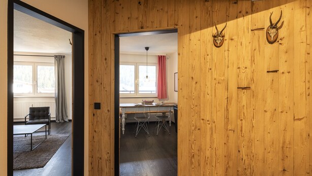 Een modern interieur met een houten wand, een eethoek en uitzicht op het exterieur.