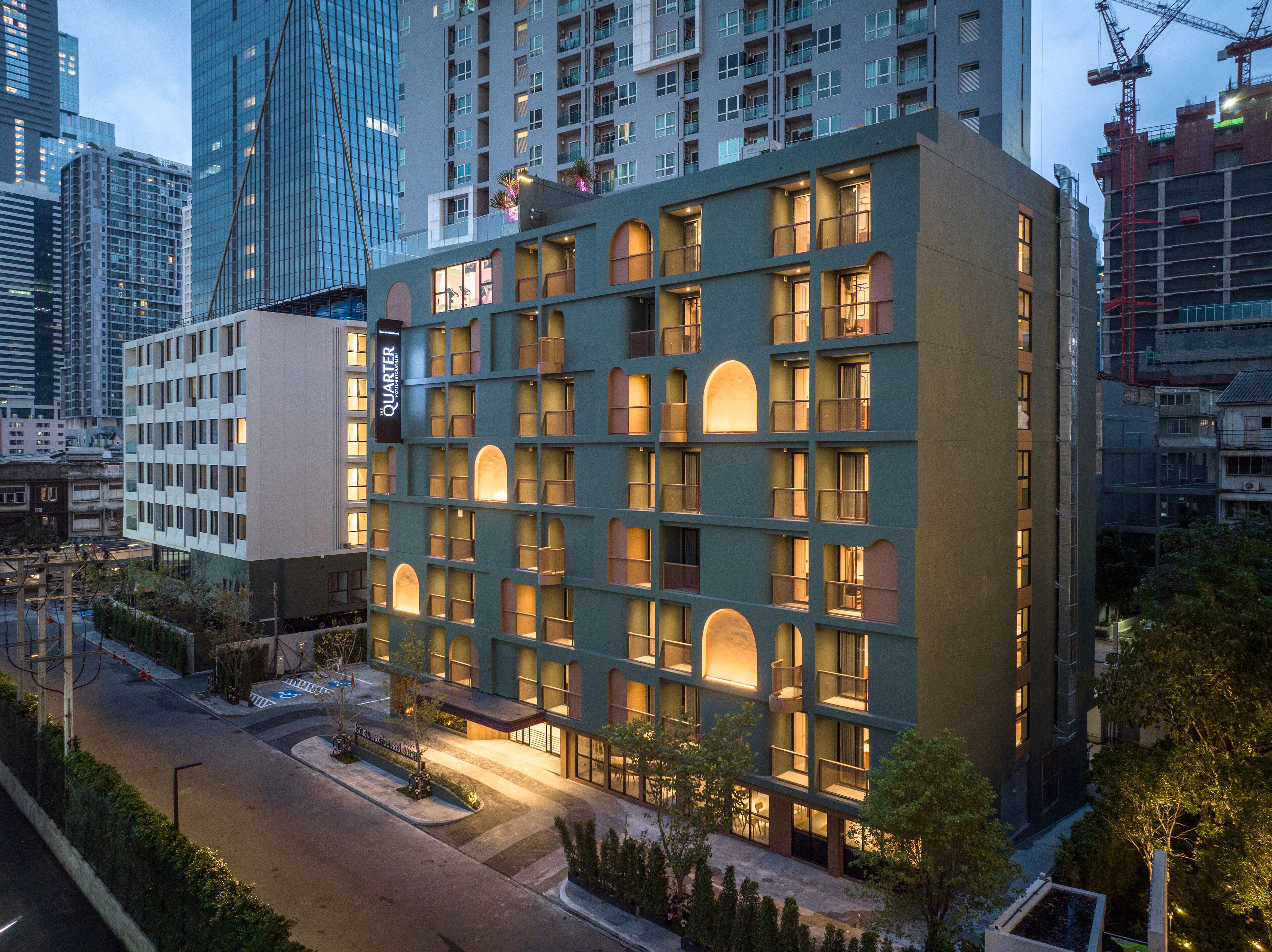 Un hôtel à plusieurs étages doté d’une façade moderne, de grandes fenêtres et d’une enseigne bien visible indiquant le nom « QUARTER ».