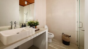 A modern bathroom with a large sink, a toilet, and a glass shower enclosure. - Omegia Canggu by Nakula (Canggu)