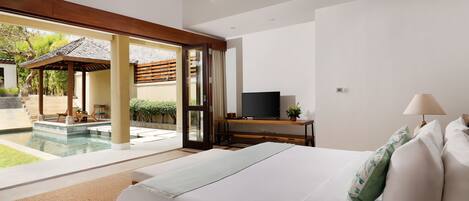 Un dormitorio con una cama grande, televisión y vistas a una piscina.