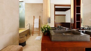 A modern bathroom with a large bathtub, a wooden vanity, and a mirror. - Omegia Canggu by Nakula (Canggu)