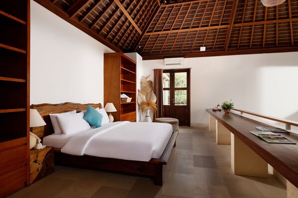 Un dormitorio con cama de madera, una mesita de noche, un escritorio y una ventana con cortinas.