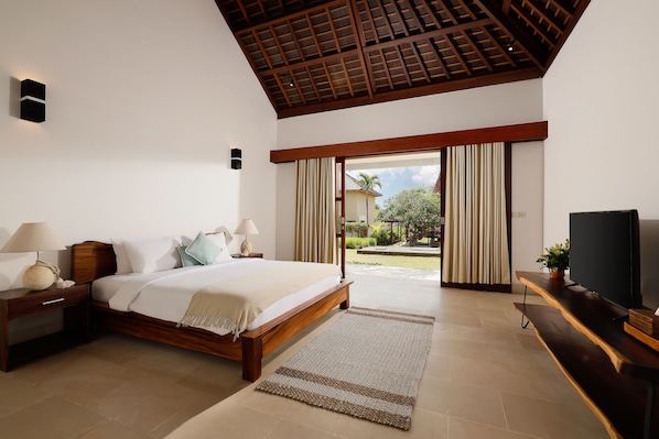 Un dormitorio con cama de madera, mesitas de noche, televisión y vistas al exterior.