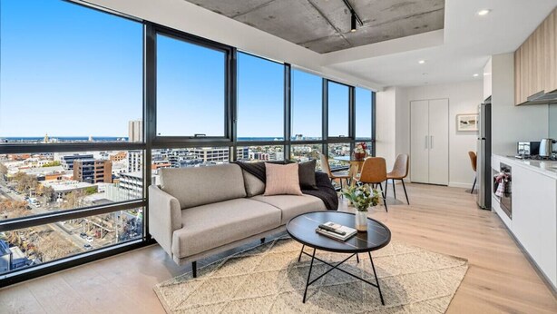 A modern living room with a large window, a sofa, a coffee table, and a view of the city. - NEW! Stature Style Southbank! (Southbank)