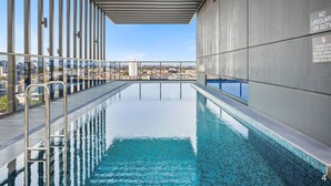 A rooftop infinity pool with a city view, metal railings, and a 'No Lifeguard on Duty' sign. - NEW! Stature Style Southbank! (Southbank)