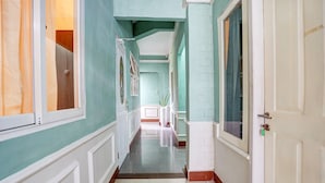 A hallway with teal walls, white trim, and a tiled floor. - OYO Life 2929 Kost Sofie Syariah (Surabaya)