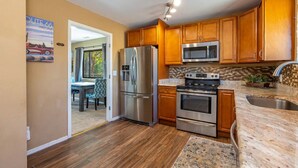 A kitchen with wooden cabinets, stainless steel appliances, and a tiled backsplash. - Flagstaff Family Retreat~Game Room~Hot Tubs (Flagstaff)