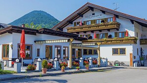 Ein zweistöckiges Gebäude mit Balkon, Außenbereich und Pflanzkübeln.