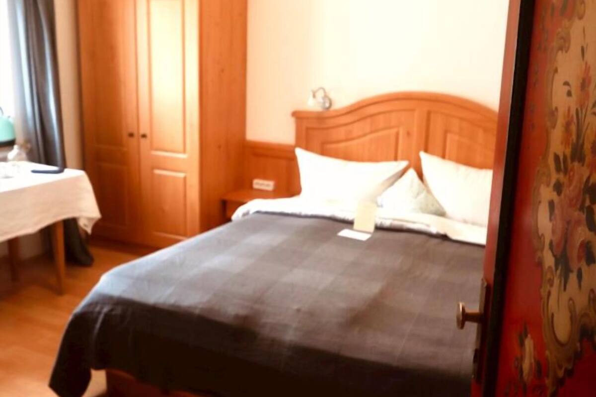 Un dormitorio con una cama de madera, una mesita de noche y un armario.