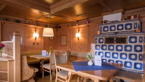 Ein gemütliches Holzinterieur mit Holztisch und -stühlen, einem dekorativen Schrank und Wandleuchten.
