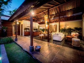 A spacious outdoor area with a dining set, a sofa, and a large planter.
