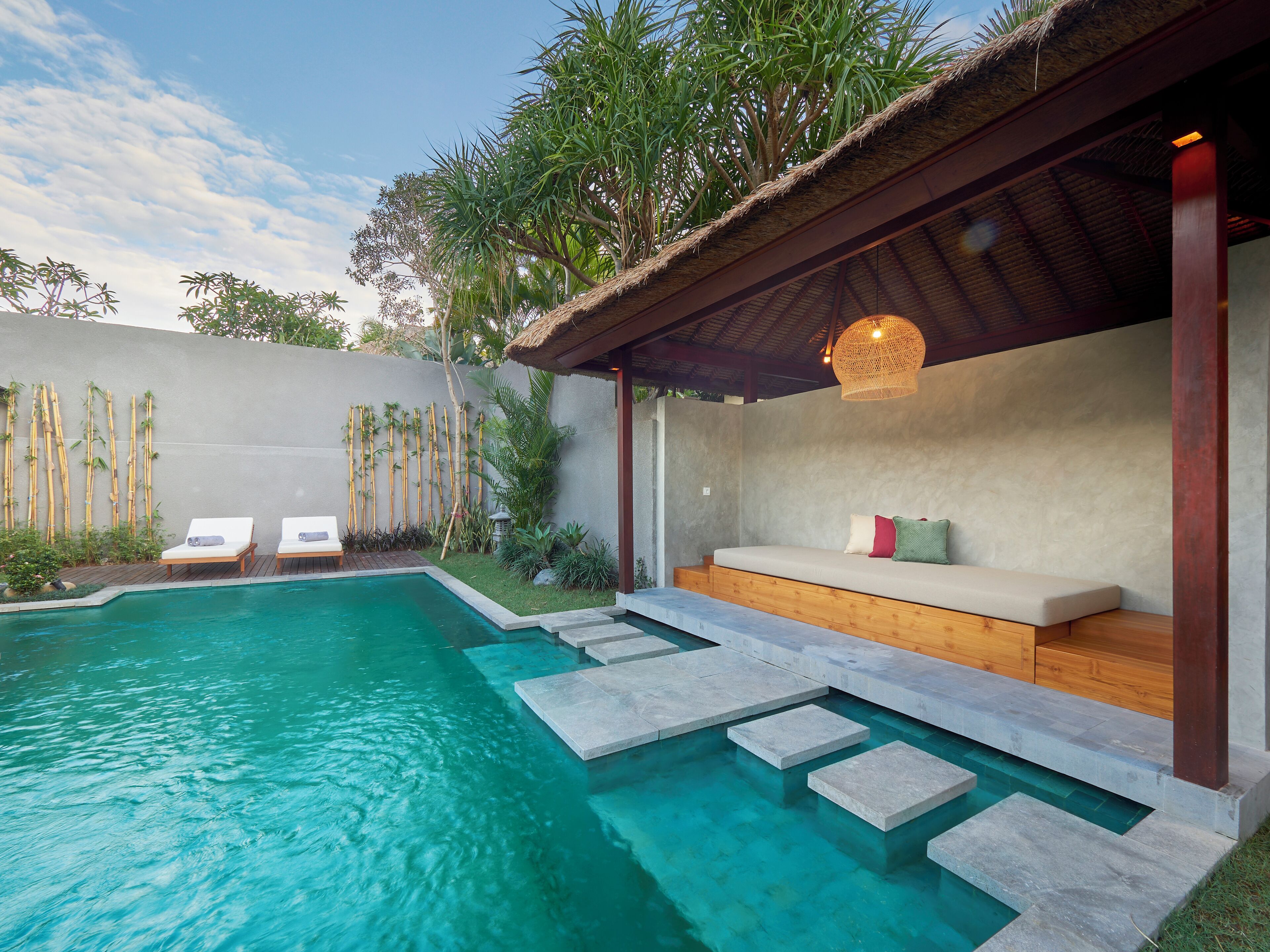 Uma área de piscina moderna ao ar livre, com espaço para sentar e espreguiçadeiras.