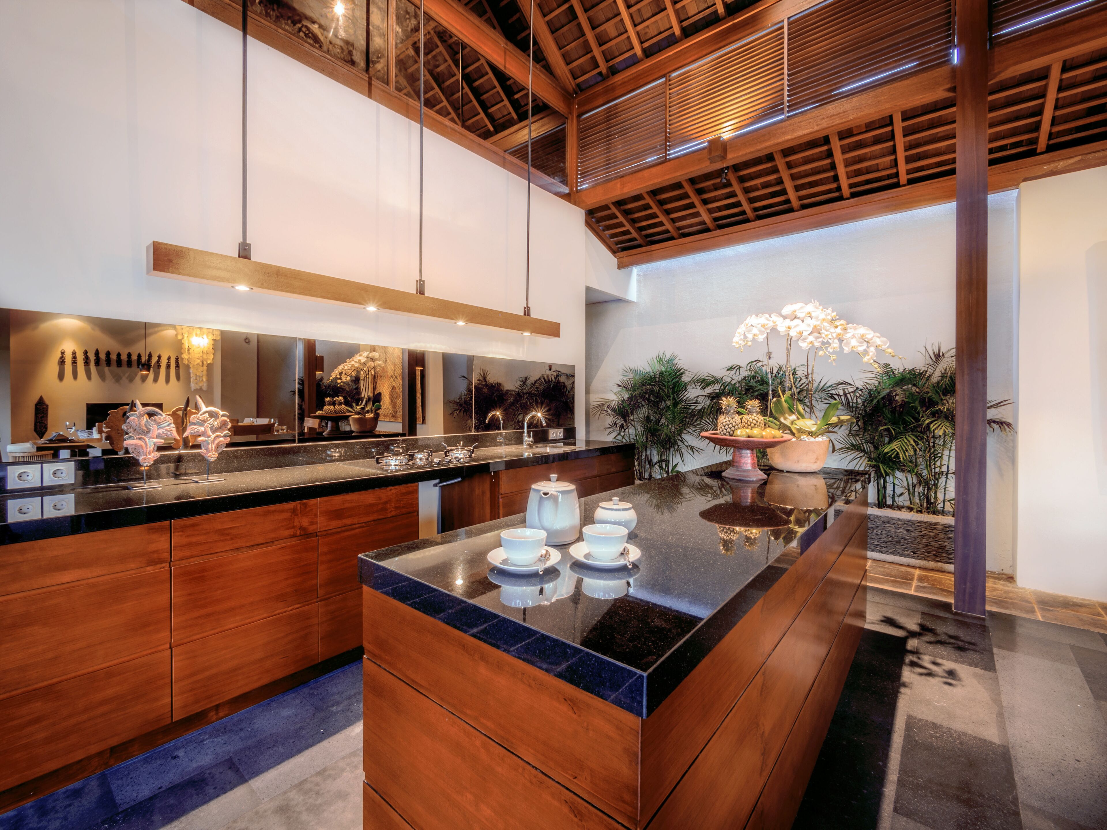 A modern kitchen with a central island, wooden cabinetry, and a variety of kitchenware.