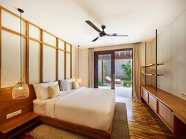 Quarto moderno com uma cama grande, um ventilador de teto, uma TV e vista para o exterior.