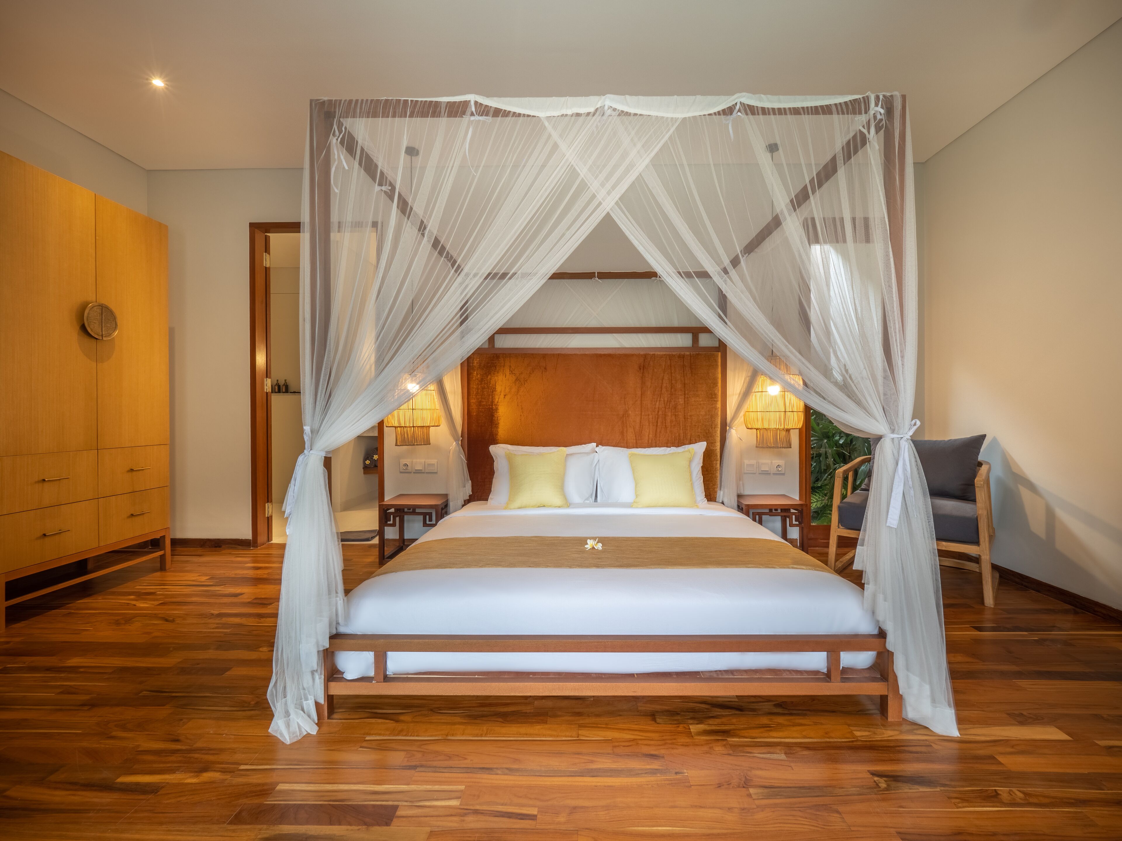 A spacious bedroom with a large bed, wooden headboard, and a canopy.