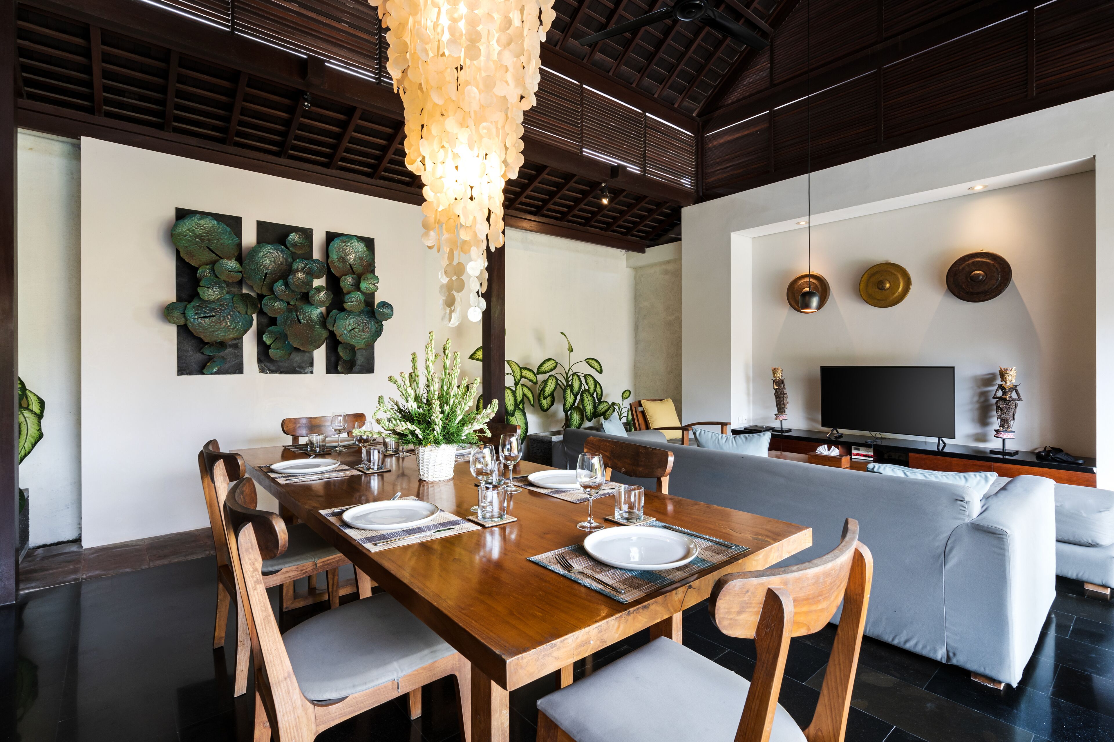 A dining area with a wooden table set for four, surrounded by chairs.