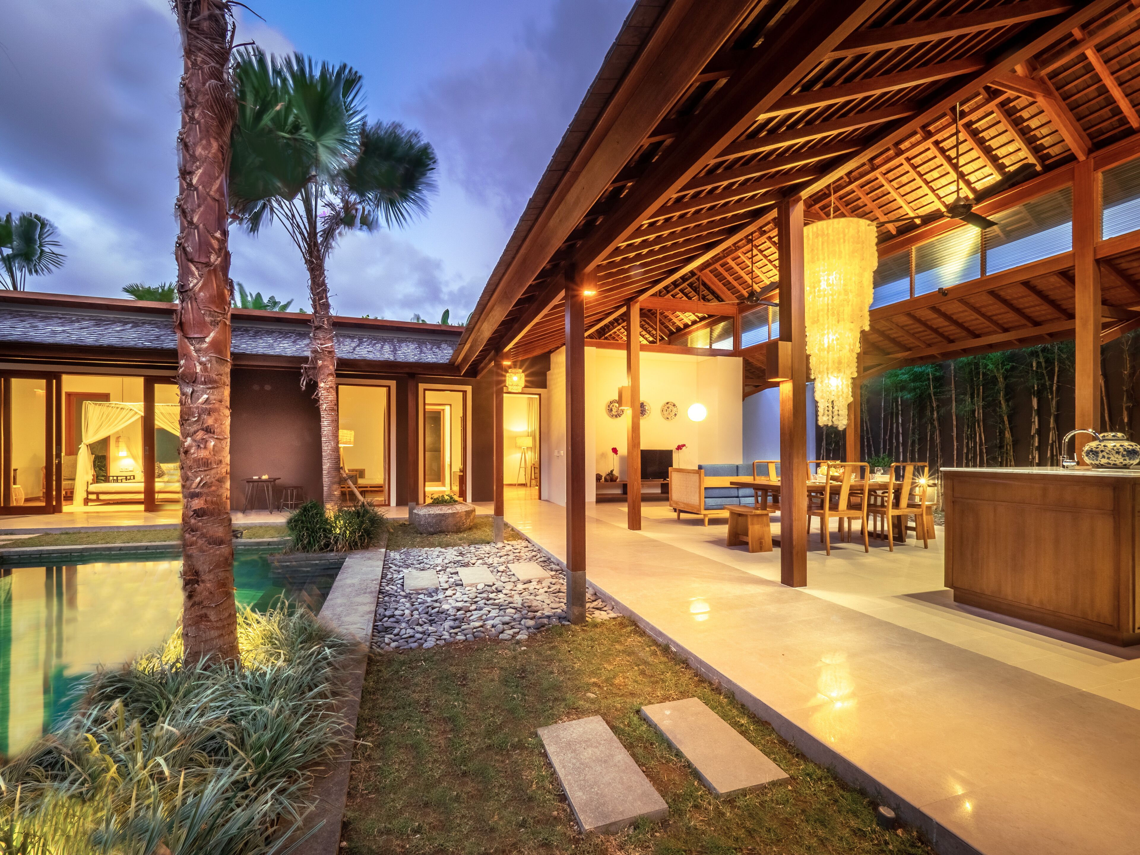 A modern resort with a swimming pool, outdoor seating, and a covered patio area.