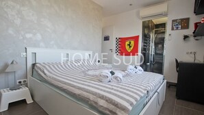 A modern bedroom with a bed, a nightstand, a desk, and a flag on the wall. - Modern 4 bedroom villa with jacuzzi  et  private pool - 25 km from Cannes (SPERACEDES)