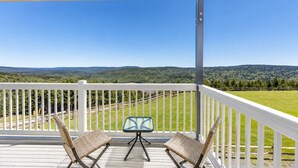Un espacio al aire libre techado con vista a un paisaje verde y colinas.