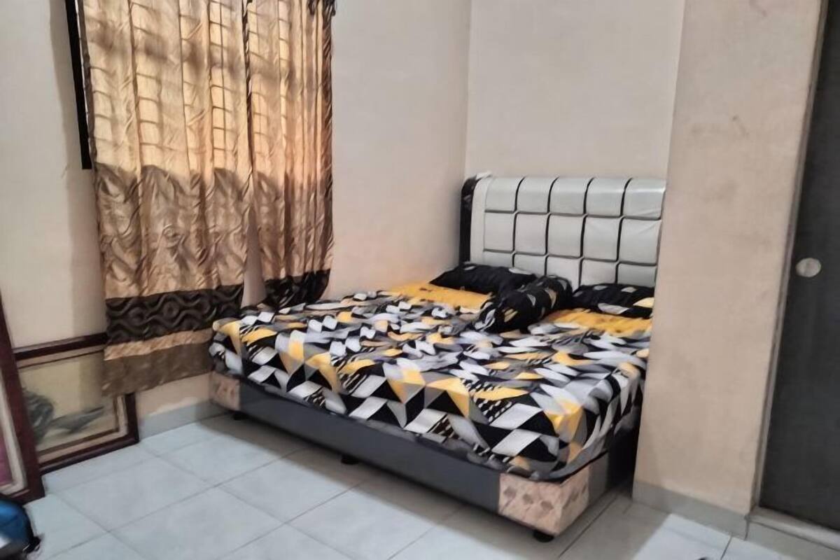 A room with a bed, curtains, and a tiled floor.