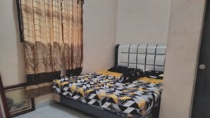 A bedroom with a bed, curtains, and a tiled floor. - Hotel O Nany Ayahanda Syariah (Medan)