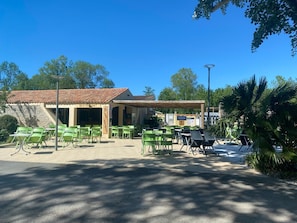 Un restaurante con terraza, techo de tejas y un letrero que indica que es un restaurante.