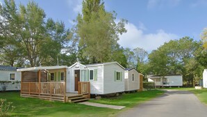 A row of mobile homes with a paved driveway and grassy areas. - Mobile Home "Le Marie Elodie 85" with 2 Shared Pools, Private Terrace & Wi-Fi (Angles)
