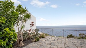 A stone-paved patio with a railing overlooking a body of water. - Holiday Home 'Moijama 12' with Sea View, Shared Pool and Wi-Fi (Los Llanos de Aridane)