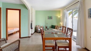 A dining area with a table, chairs, and a view through a glass door. - Holiday Home 'Moijama 6' with Sea View, Shared Pool and Wi-Fi (Los Llanos de Aridane)