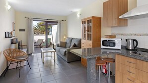 A compact kitchen with a microwave, kettle, and wooden cabinets. - Apartment 'Moijama 1' with Shared Pool, Private Terrace and Wi-Fi (Los Llanos de Aridane)