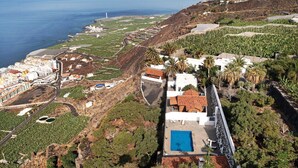 A coastal property with a swimming pool, terraced gardens, and a view of the sea. - Apartment 'Moijama 1' with Shared Pool, Private Terrace and Wi-Fi (Los Llanos de Aridane)