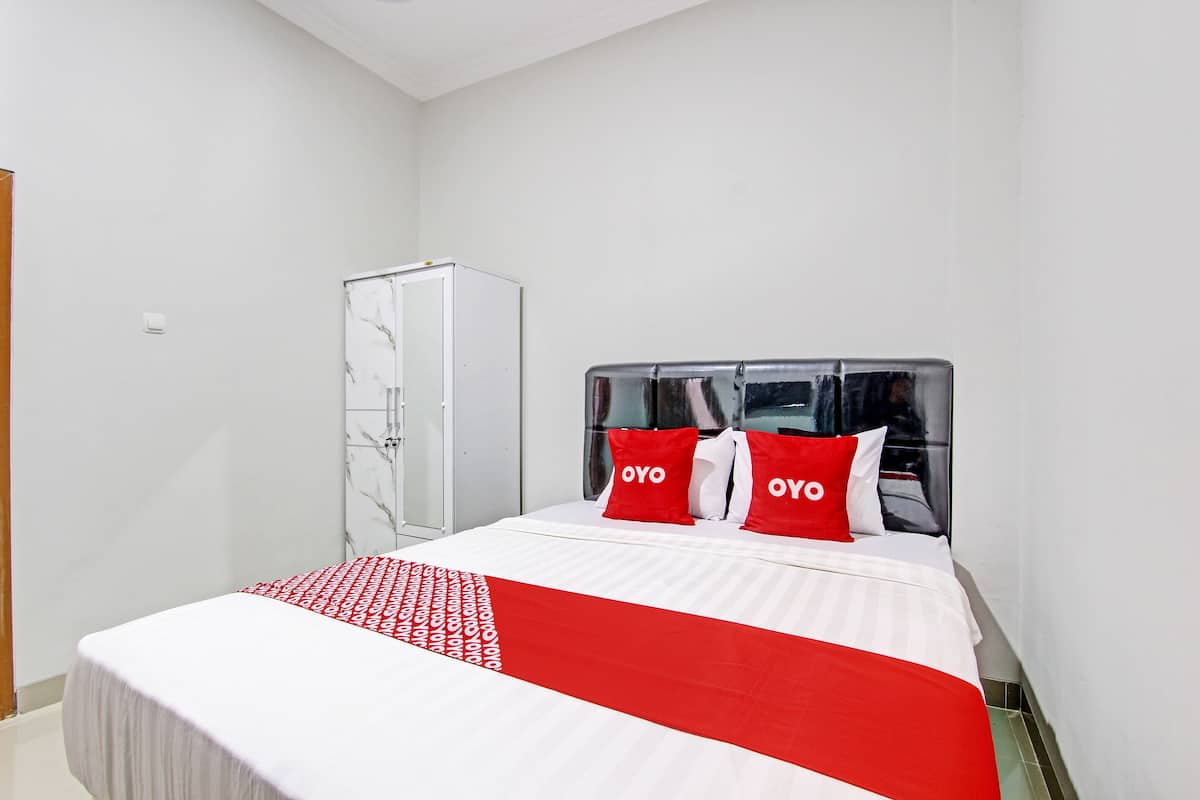 Quarto de hotel bem arrumado com cama, guarda-roupa e espelho.