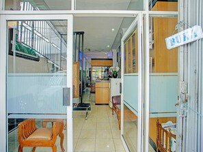 A corridor with a wooden bench, a refrigerator, and a sign reading "BUKA". - SPOT ON 92905 Sutomo Residence Syariah Near Taman Tugu Padang Area (Lawang)