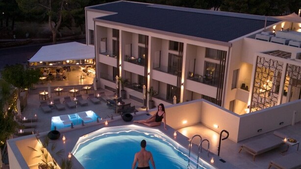 A modern hotel with a rooftop pool area, outdoor seating, and a view of the surrounding landscape. - Inea Sole Boutique Hotel (Chania)