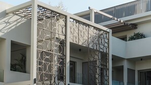 A modern building with a pool, outdoor seating, and a decorative facade. - Inea Sole Boutique Hotel (Chania)
