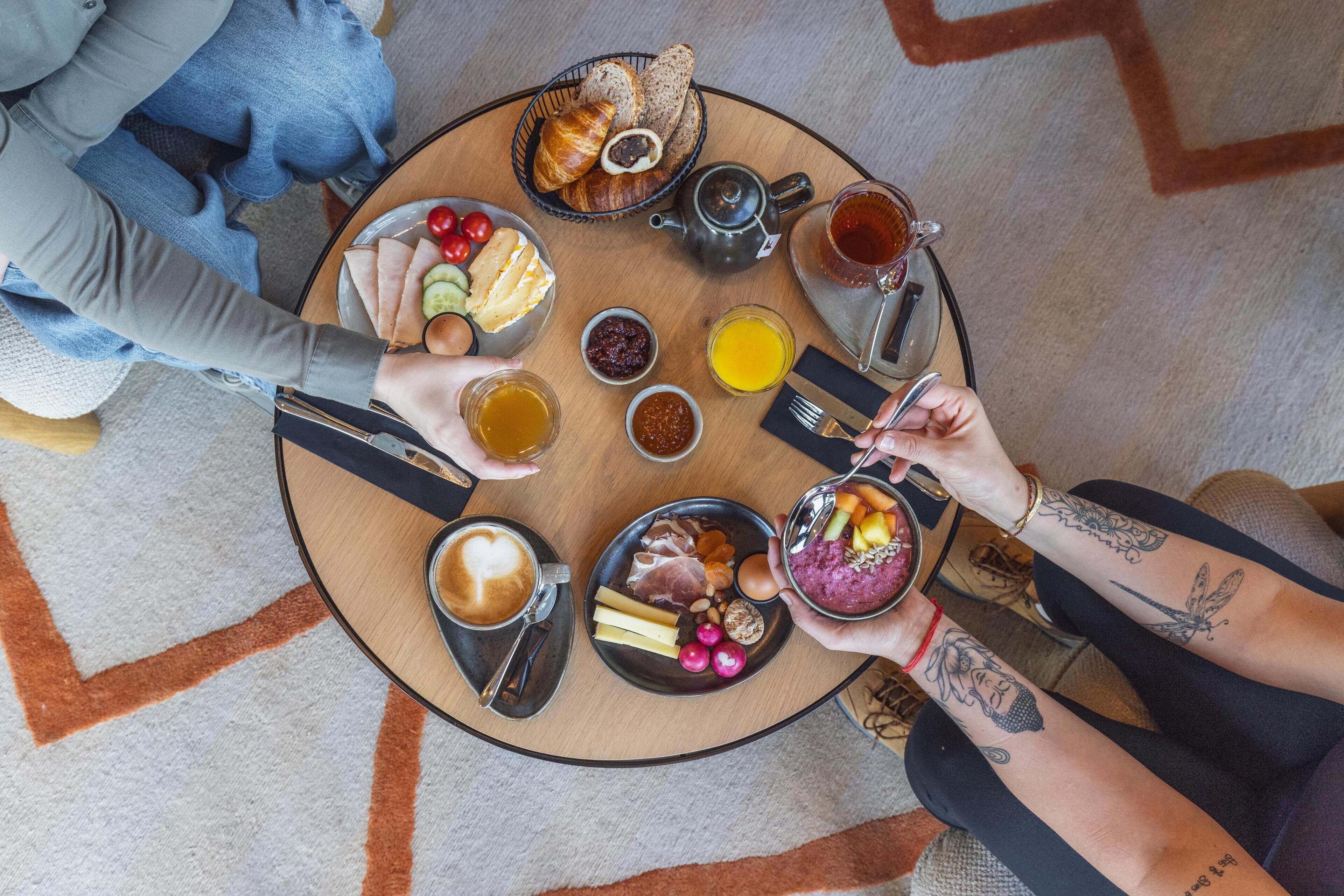 A round table with breakfast items including bread, eggs, and fruit.