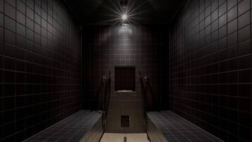 A narrow, tiled hallway with a central light fixture and a small window.