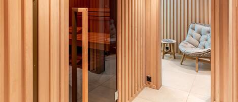 A corridor with wooden slats, a glass door leading to a room, and a wicker chair in the distance.