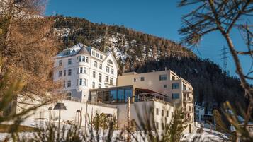 Un hotel de varios pisos, con amplias ventanas y vista a una montaña nevada.