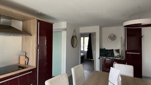 Eine moderne Küche mit einer Holzarbeitsplatte, weißen Stühlen und einem Esstisch.