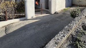 Ein zweigeschossiges Gebäude mit weißer Fassade, einem Balkon im oberen Stockwerk und einem verschlossenen Eingang.