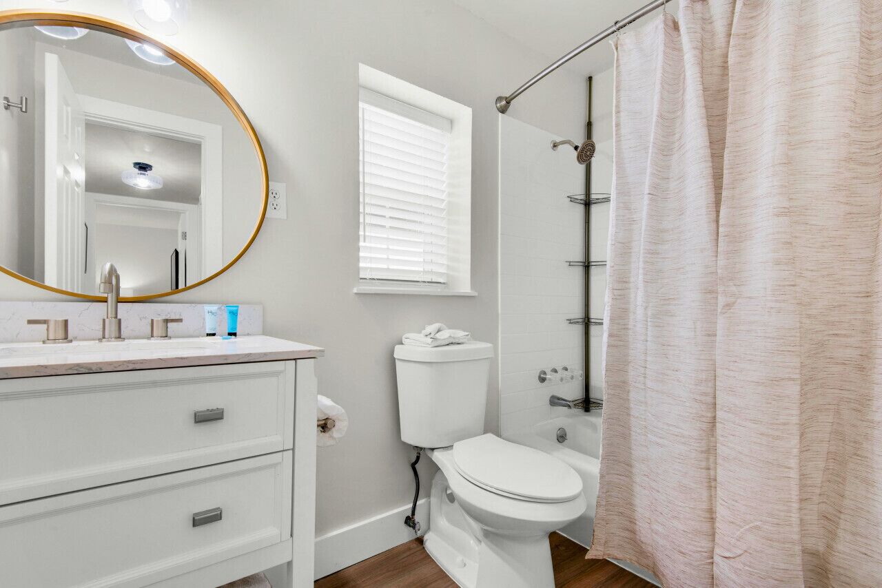 A bathroom with a toilet, sink, and shower.