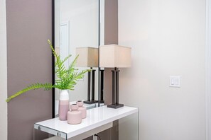 En badrumsmöbel med en spegel, en lampa och en krukväxt.