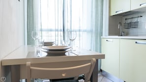 Apartamento básico (1 Bedroom) | Cocina privada | Microondas, horno y mesa de comedor
