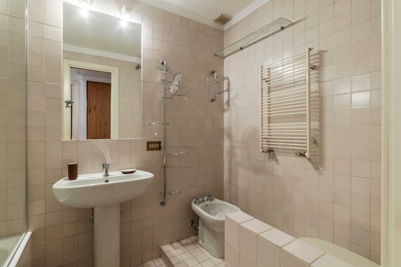 A bathroom with a sink, mirror, shower, and bathtub.