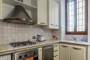 A kitchen with a gas stove, oven, dishwasher, and a window with a view. - A stone’s throw from the Colosseum! (Roma)